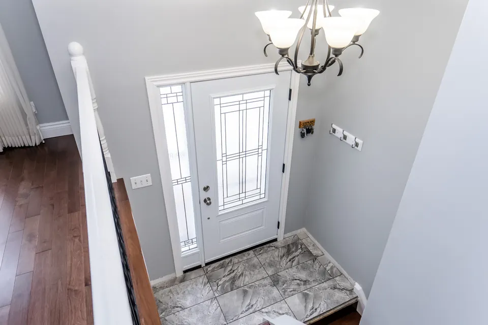 A bright entranceway with a white front door and fresh trim