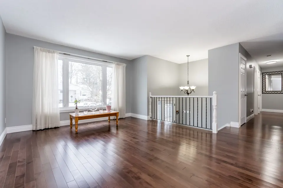A bright living room with soft grey walls, white trim and hardwood floors