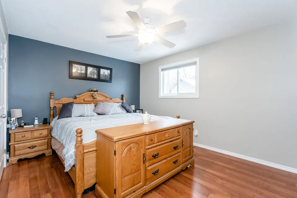 A primary bedroom with a blue feature wall behind the bed